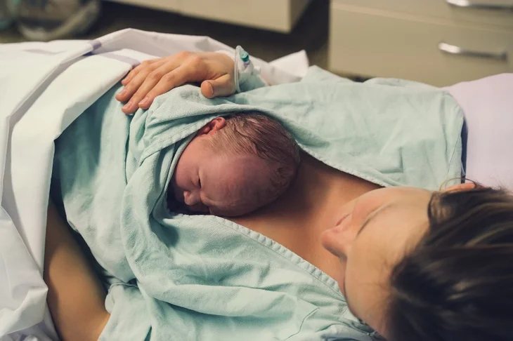 Noworodek leży na piersi mamy tuż po porodzie - kontakt skóra do skóry